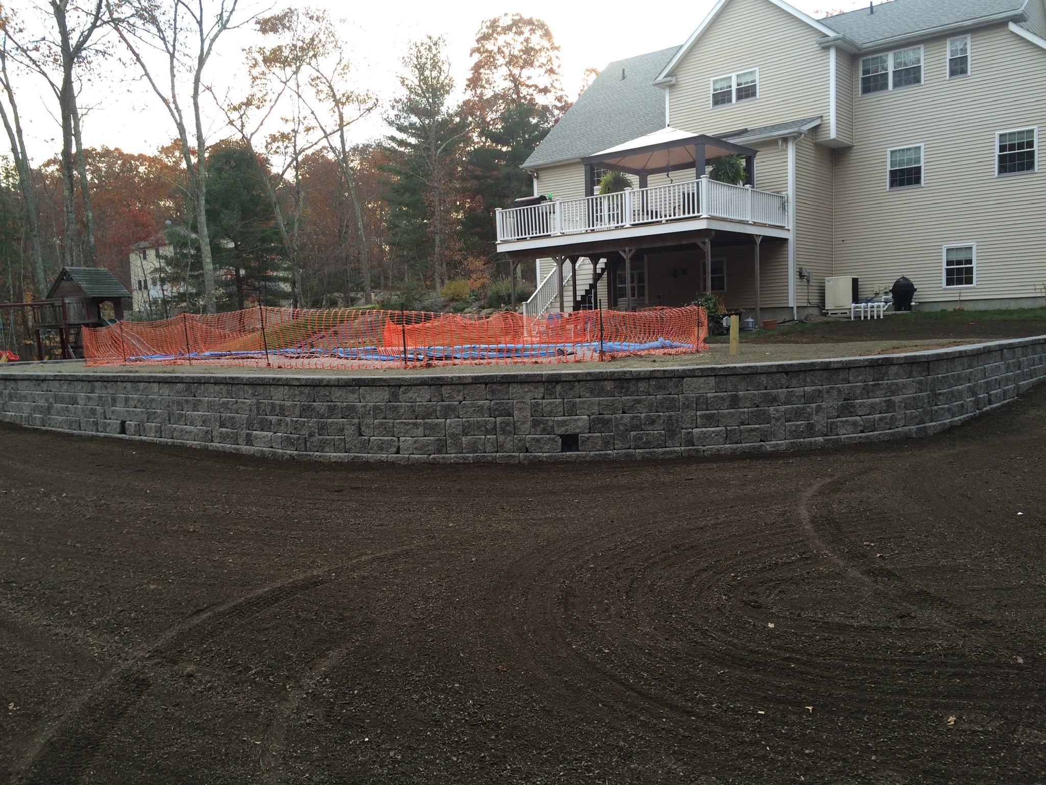 House with stone wall and land being graded
